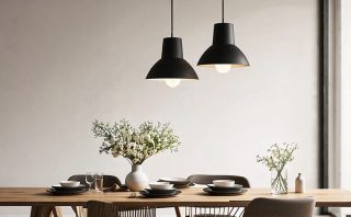 Modern pendant light illuminating a stylishly set dining table with elegant decor and flowers, creating a warm and inviting atmosphere.