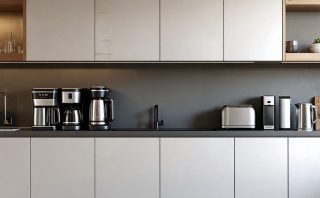 A modern kitchen with sleek cabinetry featuring an under cabinet angled power strip. Multiple appliances are plugged in, demonstrating the space-saving and convenience of the power strip.